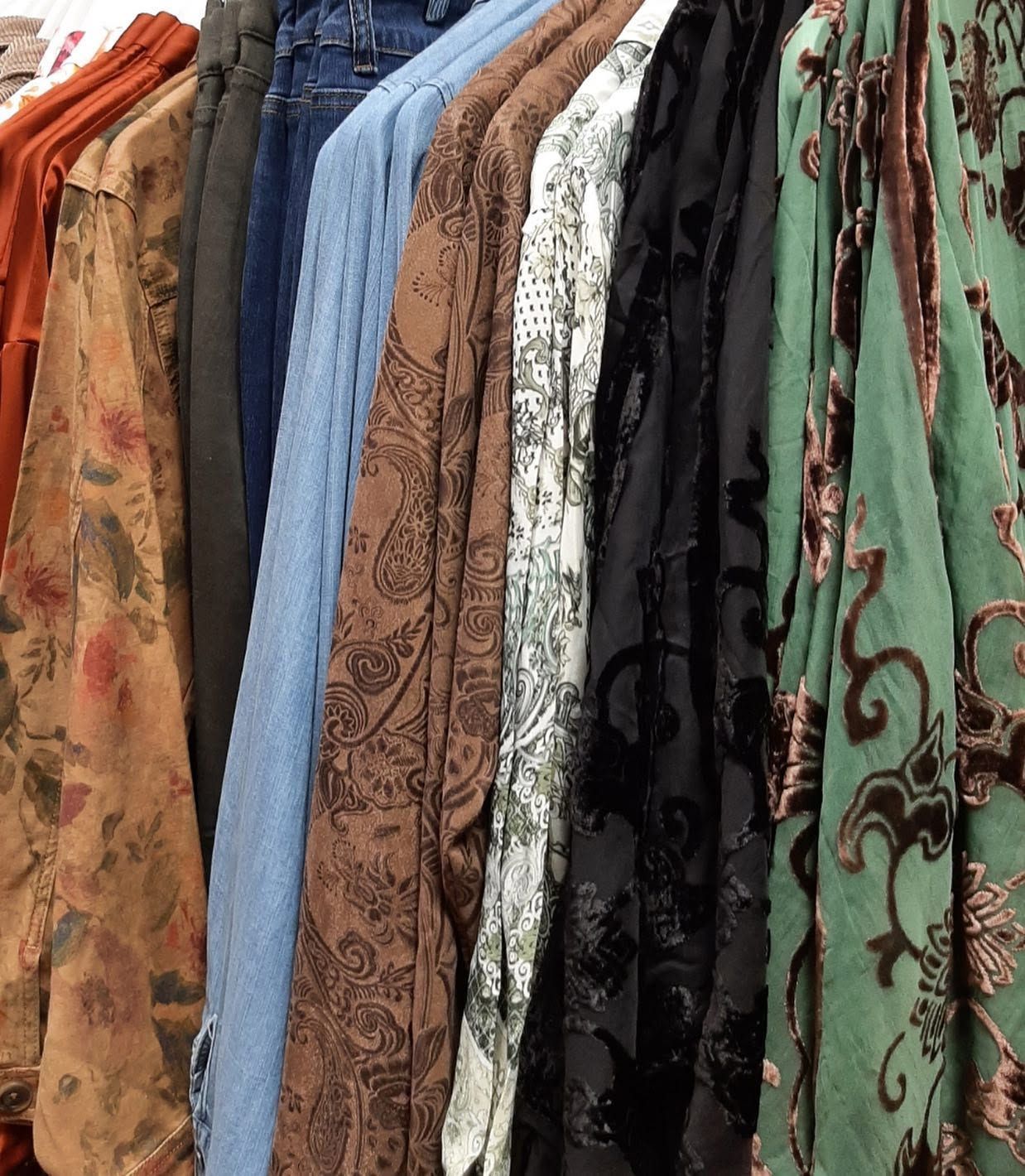 Rows of colorful patterned fabrics hanging on display in a shop