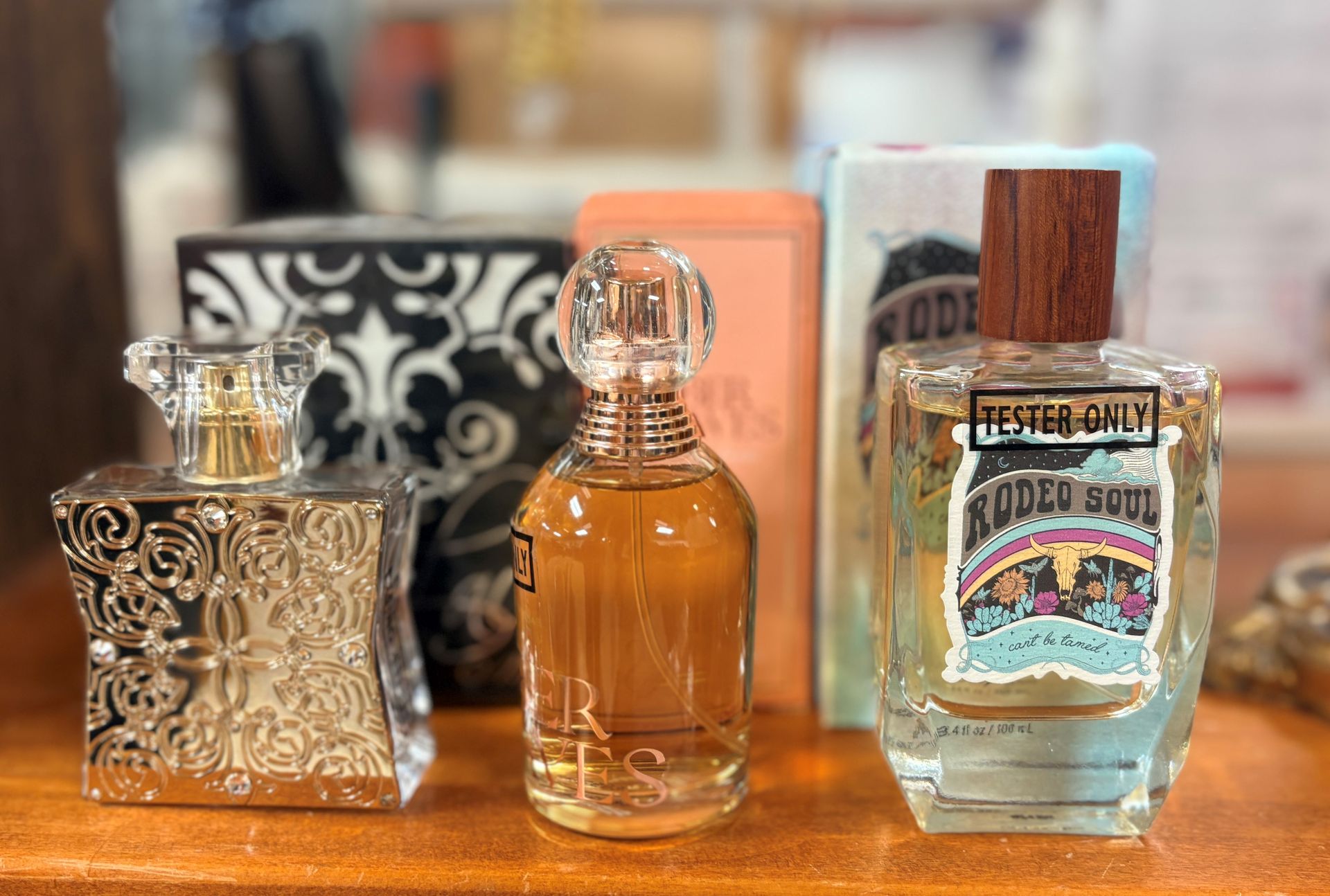 Three ornate glass bottles on a wooden shelf, including one labeled “Espresso Martini.”