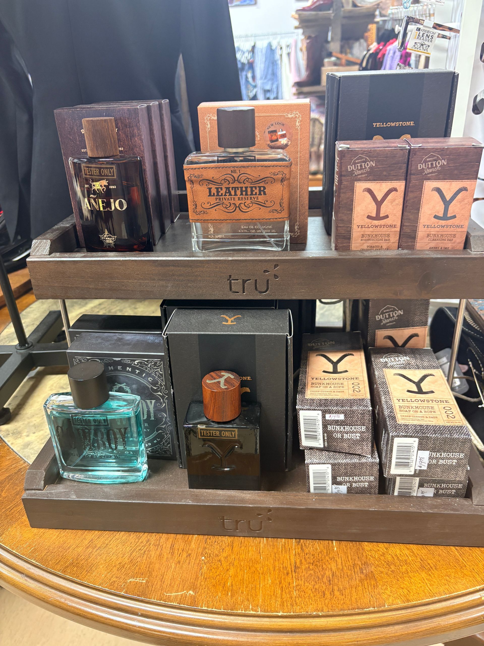 Display of assorted boxed and bottled perfumes on a metal shelf and wooden base, including YSL fragrance boxes.
