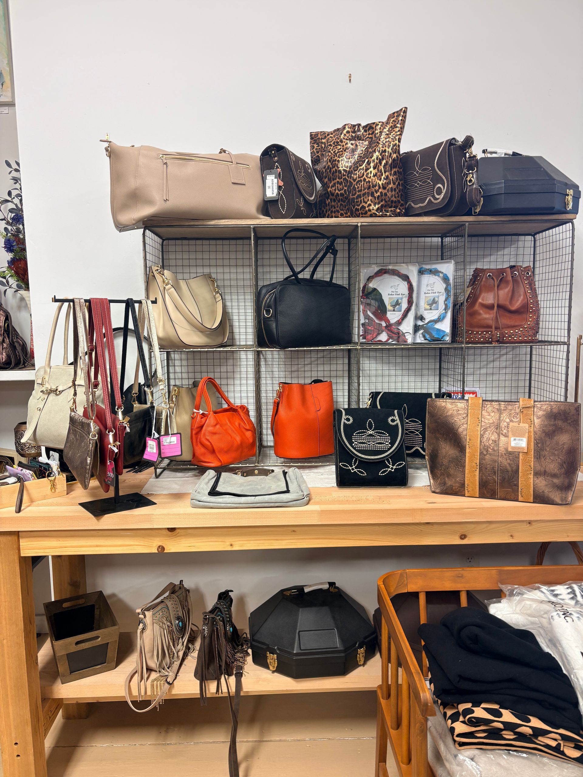 Handbags and accessories displayed on shelves in a boutique shop