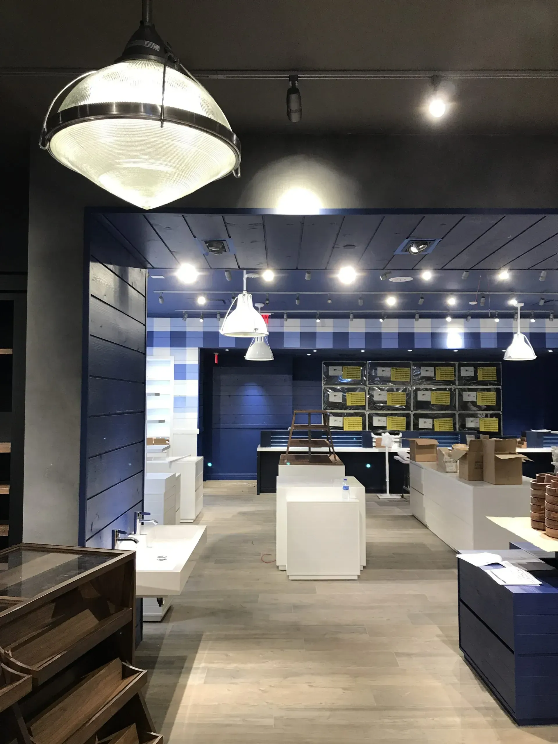 Interior view of a Bath & Body Works store with blue and white accents, white displays, and overhead lighting.