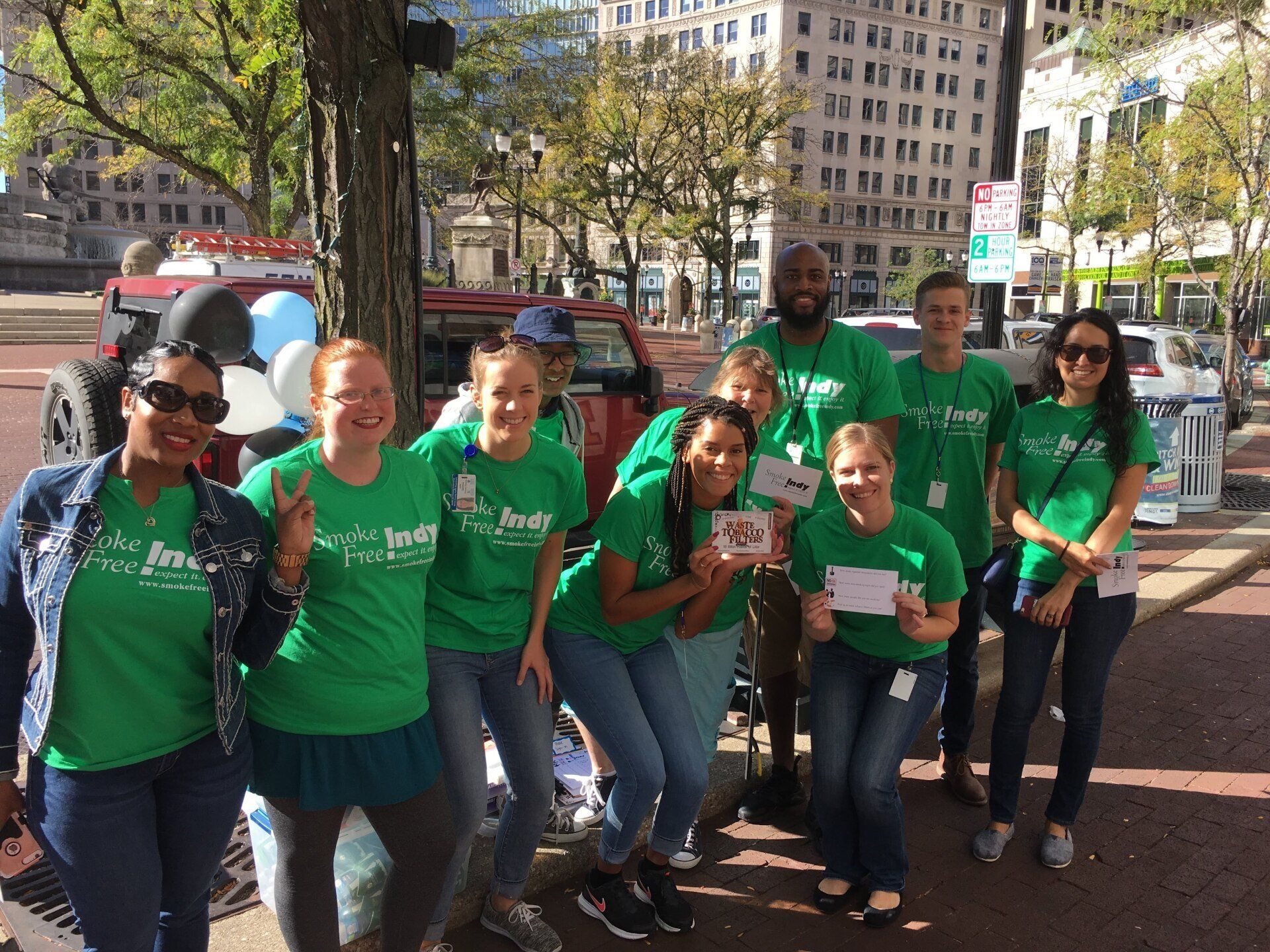 Brittaney Jenkins in a group of 10 public health organizational members all smiling and wearing green tshirts