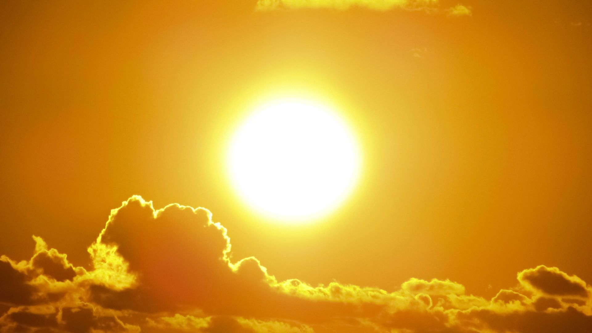 The sun is shining brightly through the clouds in the sky.
