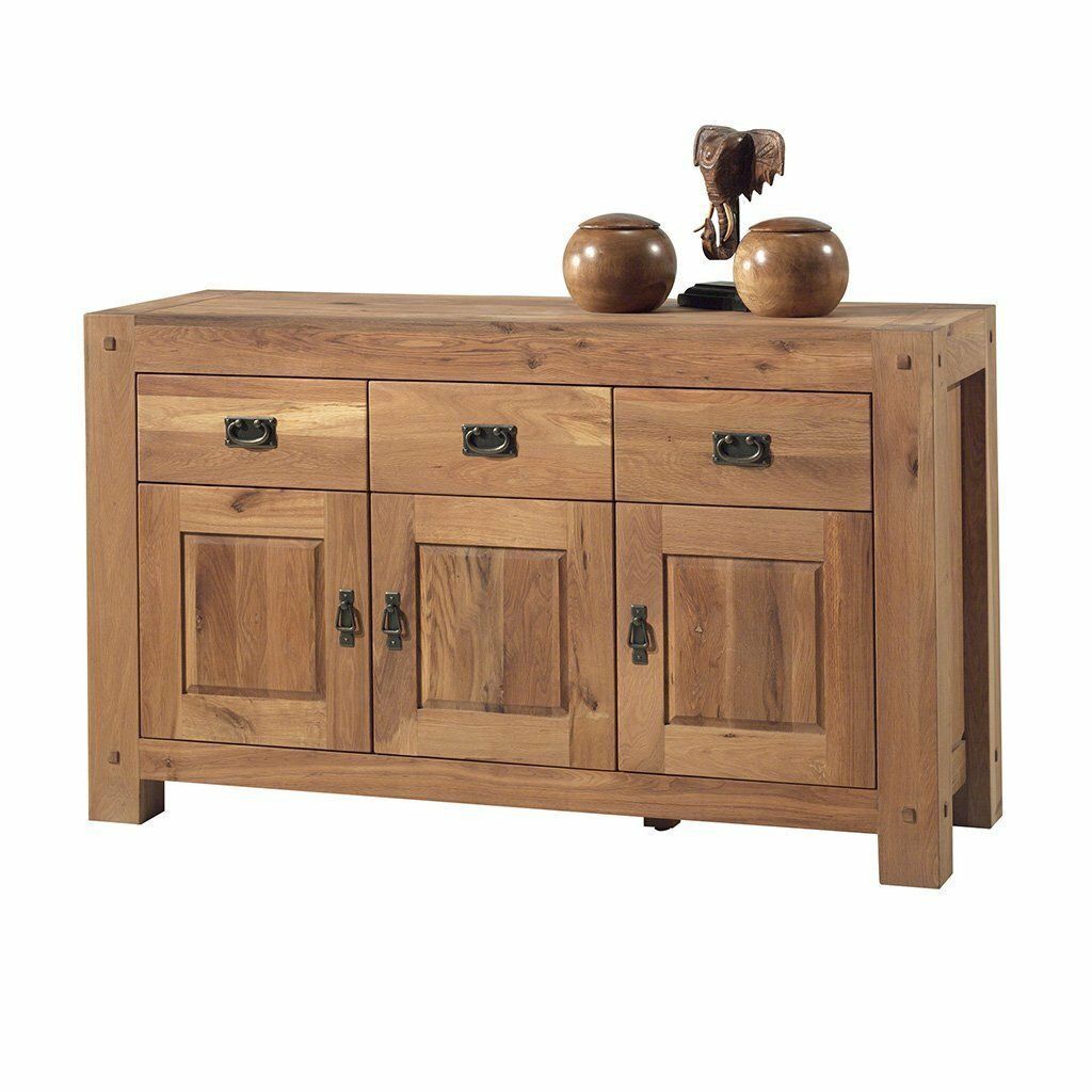 Buffet en bois à trois tiroirs et deux portes, surmonté d'objets décoratifs.