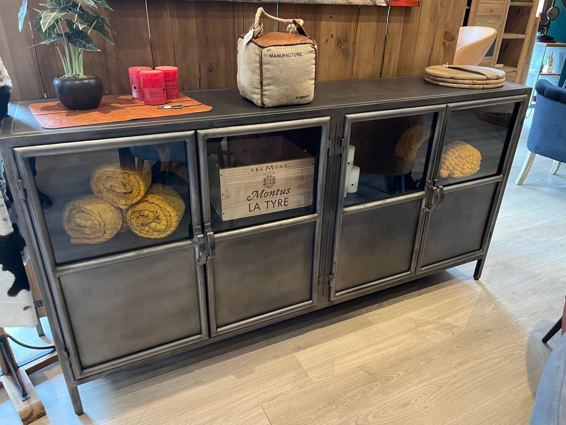 Vitrine en métal et en verre présentant des articles sur le dessus et à l'intérieur, dans un environnement de magasin.