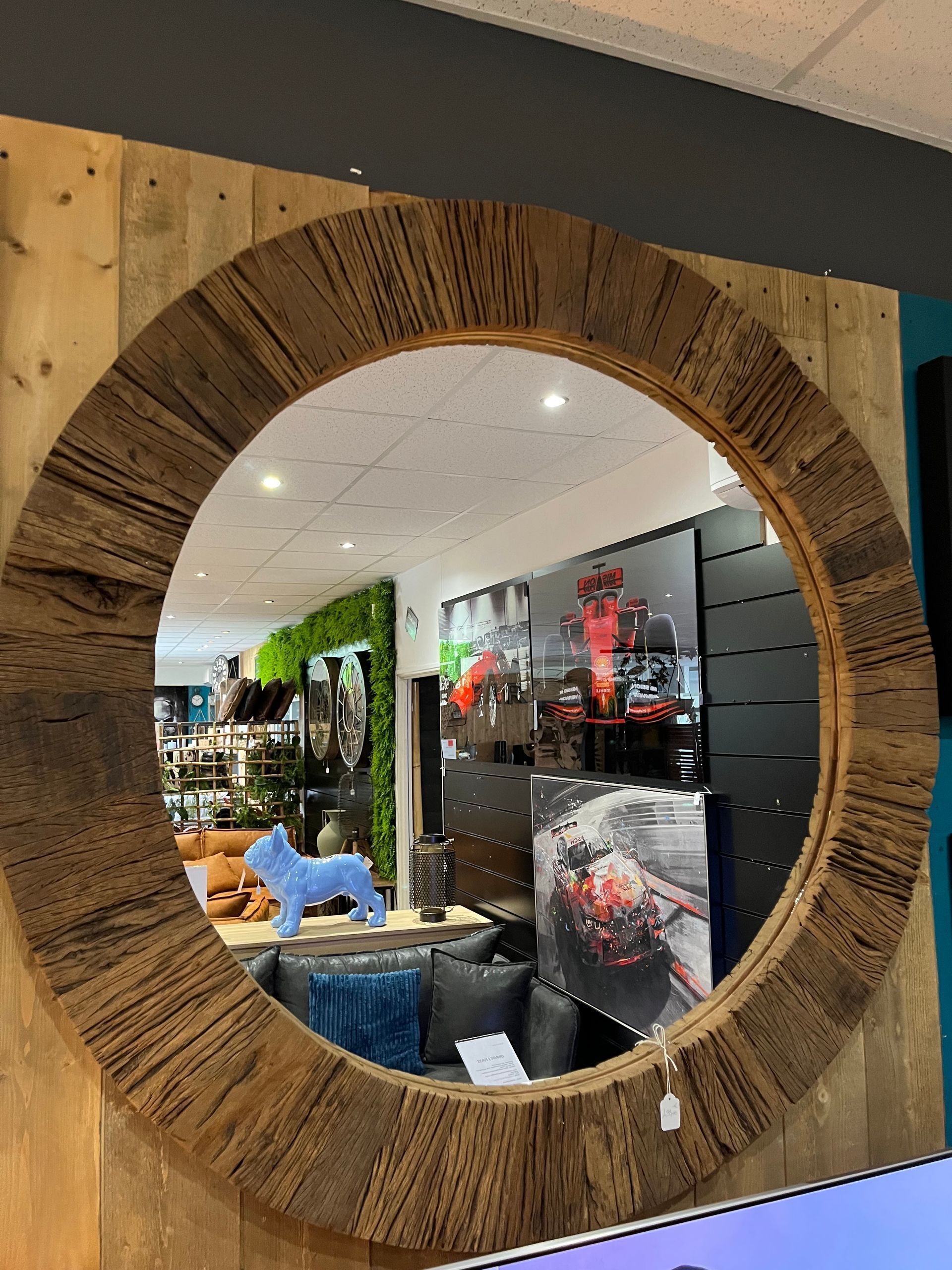 Un miroir rond avec un cadre en bois est accroché au mur.