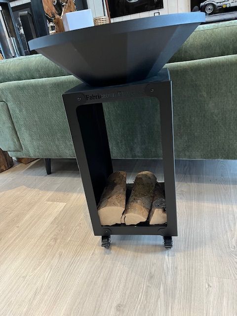 Brasero noir avec étagère de rangement contenant des bûches