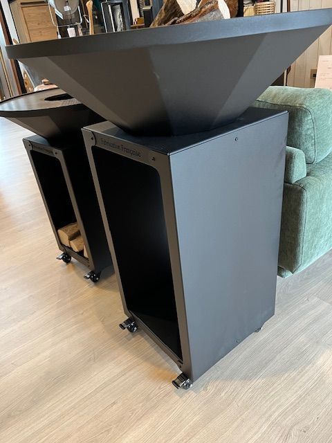 Cheminée d'extérieur noire sur pied avec étagère de rangement et roulettes. Aménagement intérieur.