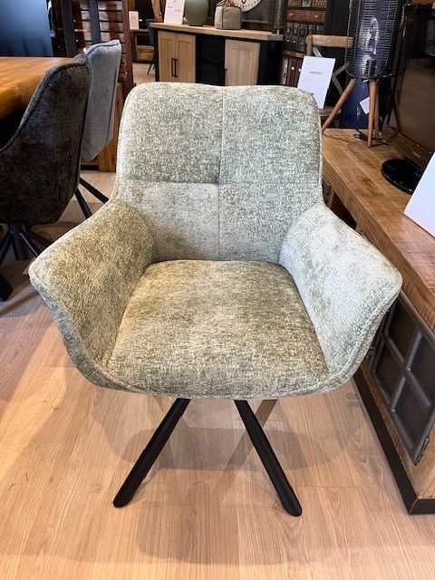 Fauteuil pivotant rembourré vert olive avec pieds en métal noir.