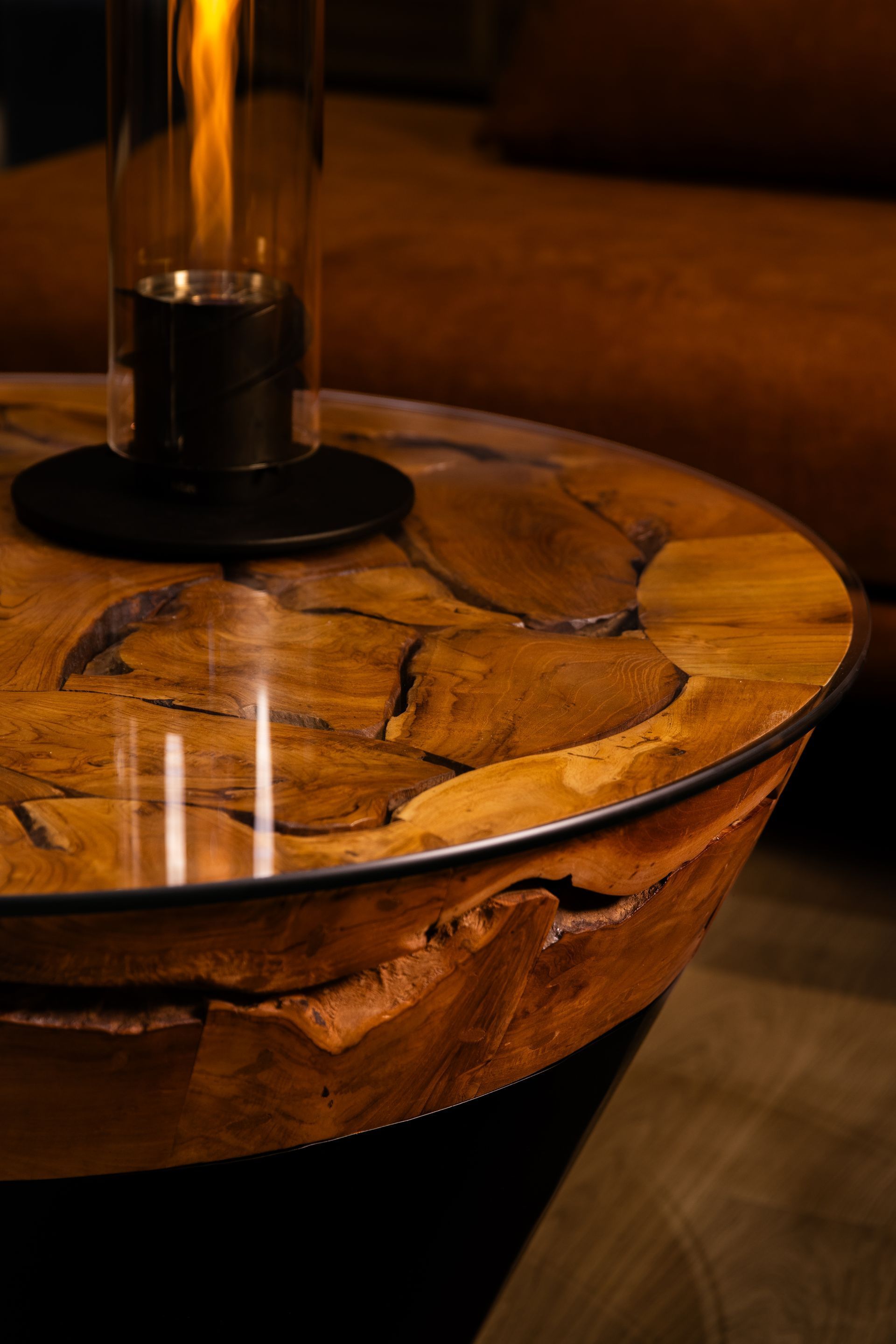 Deux cheminées de table allumées sur une table basse rustique en bois ; intérieur tamisé et chaleureux.