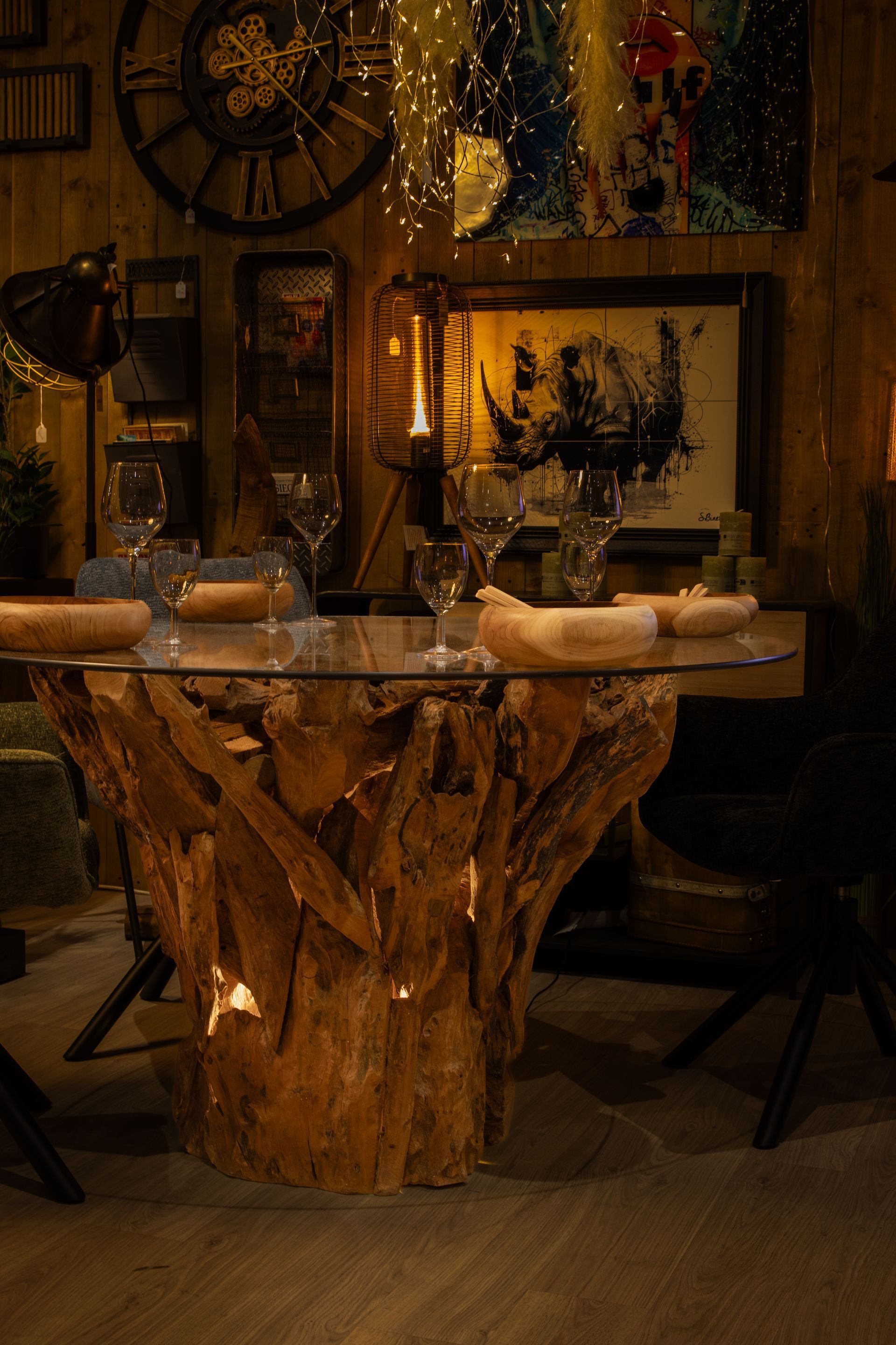Table de salle à manger rustique avec un pied en tronc d'arbre, dressée pour le dîner.