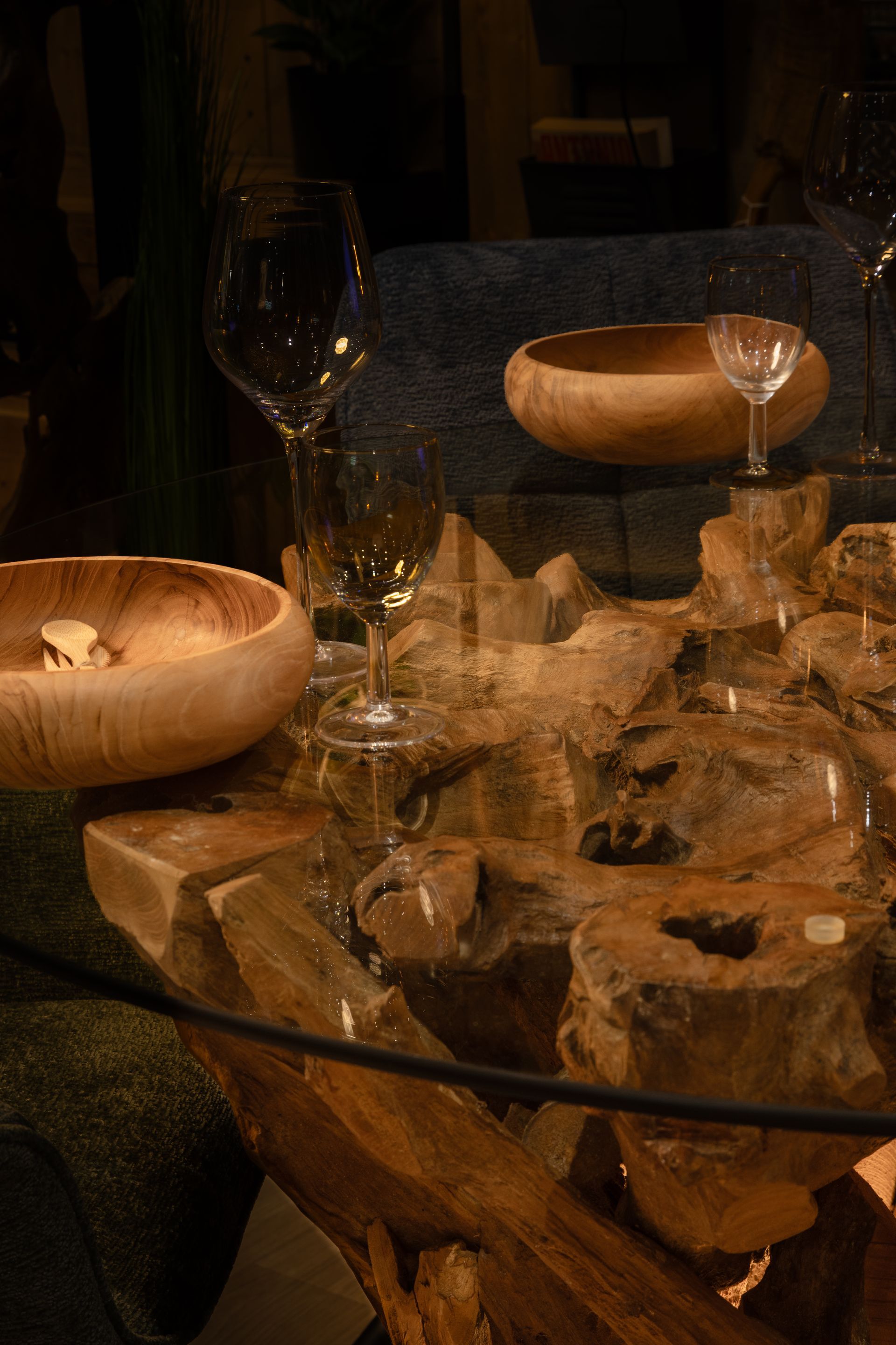 Table de salle à manger rustique avec un pied en tronc d'arbre, dressée pour le dîner.