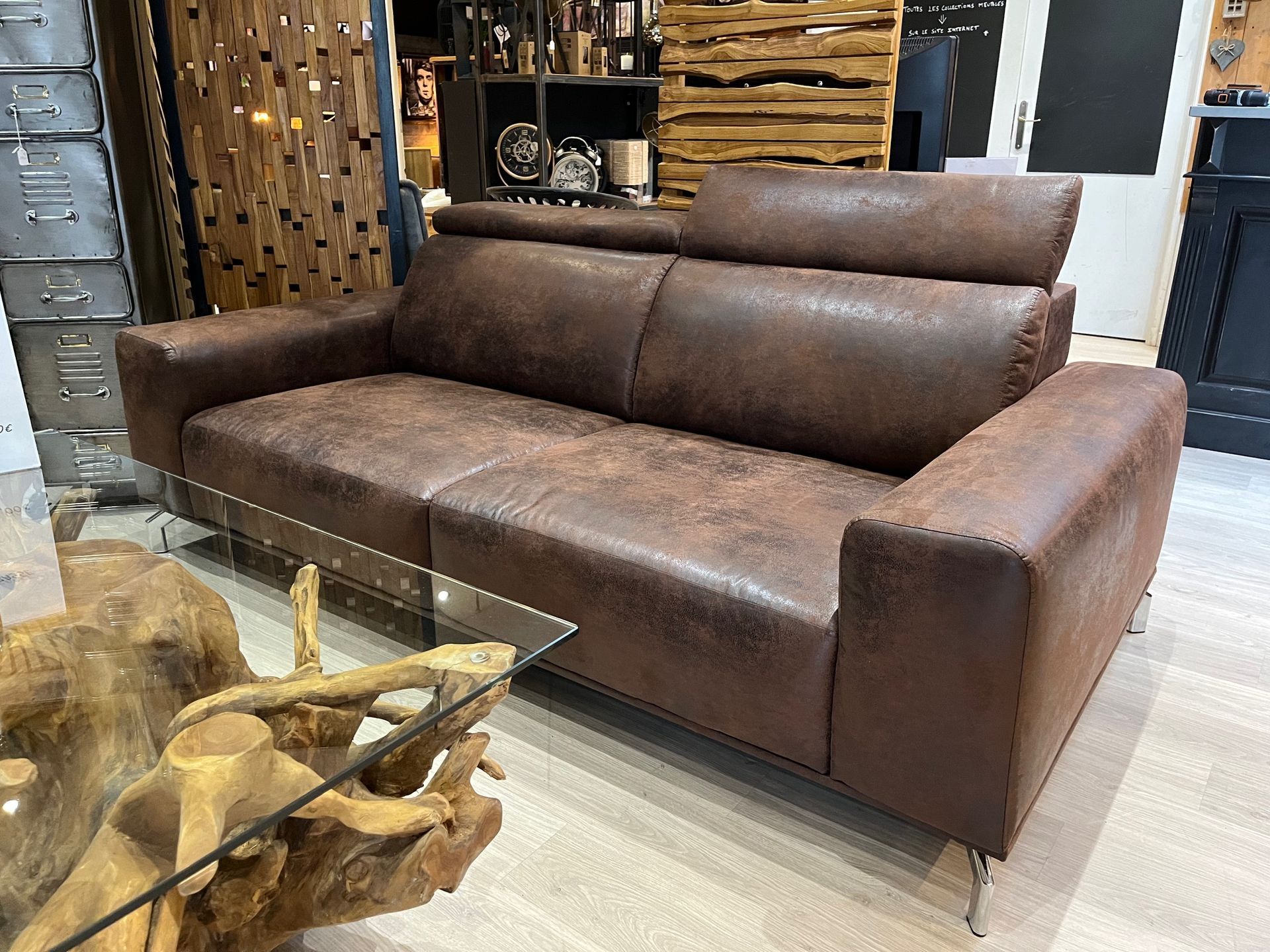 Canapé en cuir marron avec appuie-têtes réglables, dans un intérieur domestique.