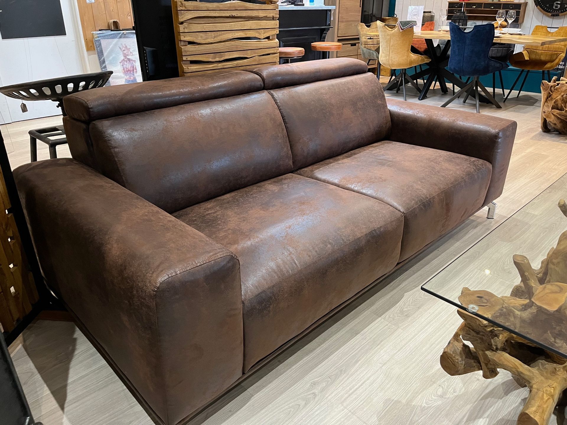 Canapé en cuir marron avec appuie-têtes réglables, dans un intérieur domestique.