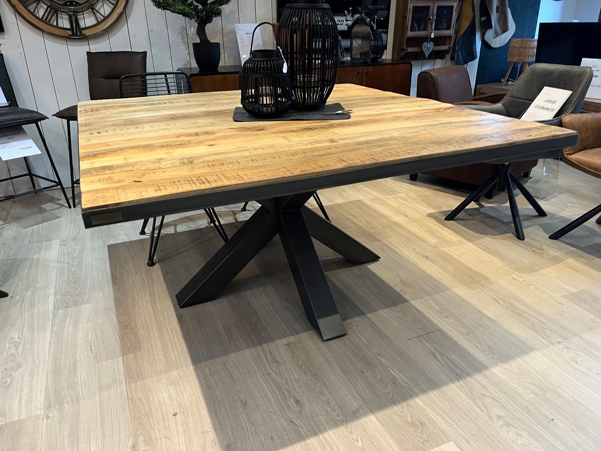 Table de salle à manger carrée en bois avec pieds en métal noir.