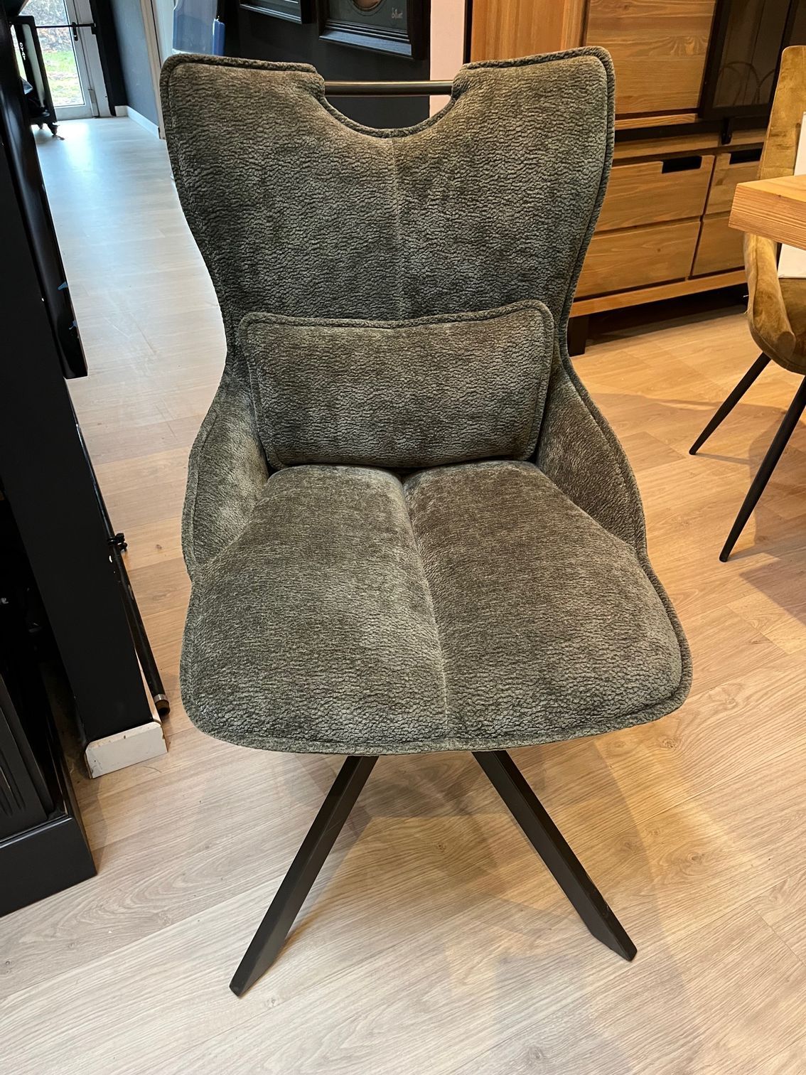 Fauteuil pivotant gris rembourré avec pieds noirs.