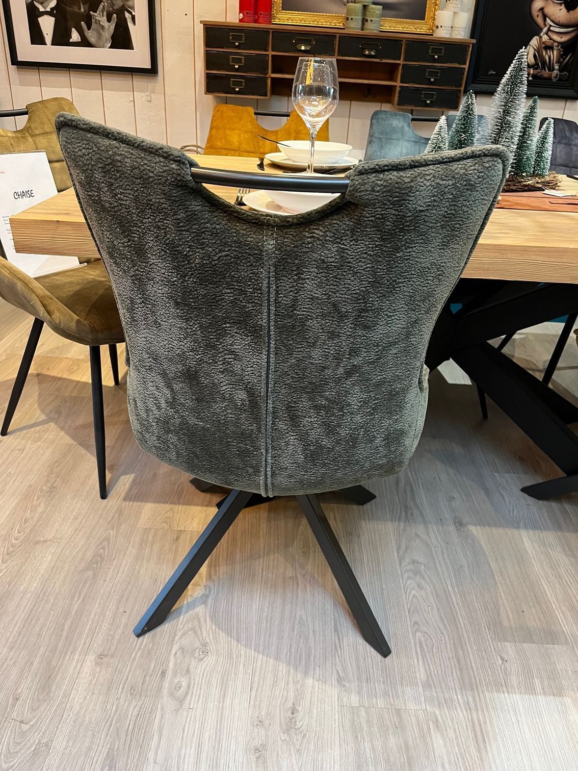 Fauteuil pivotant gris rembourré avec pieds noirs.