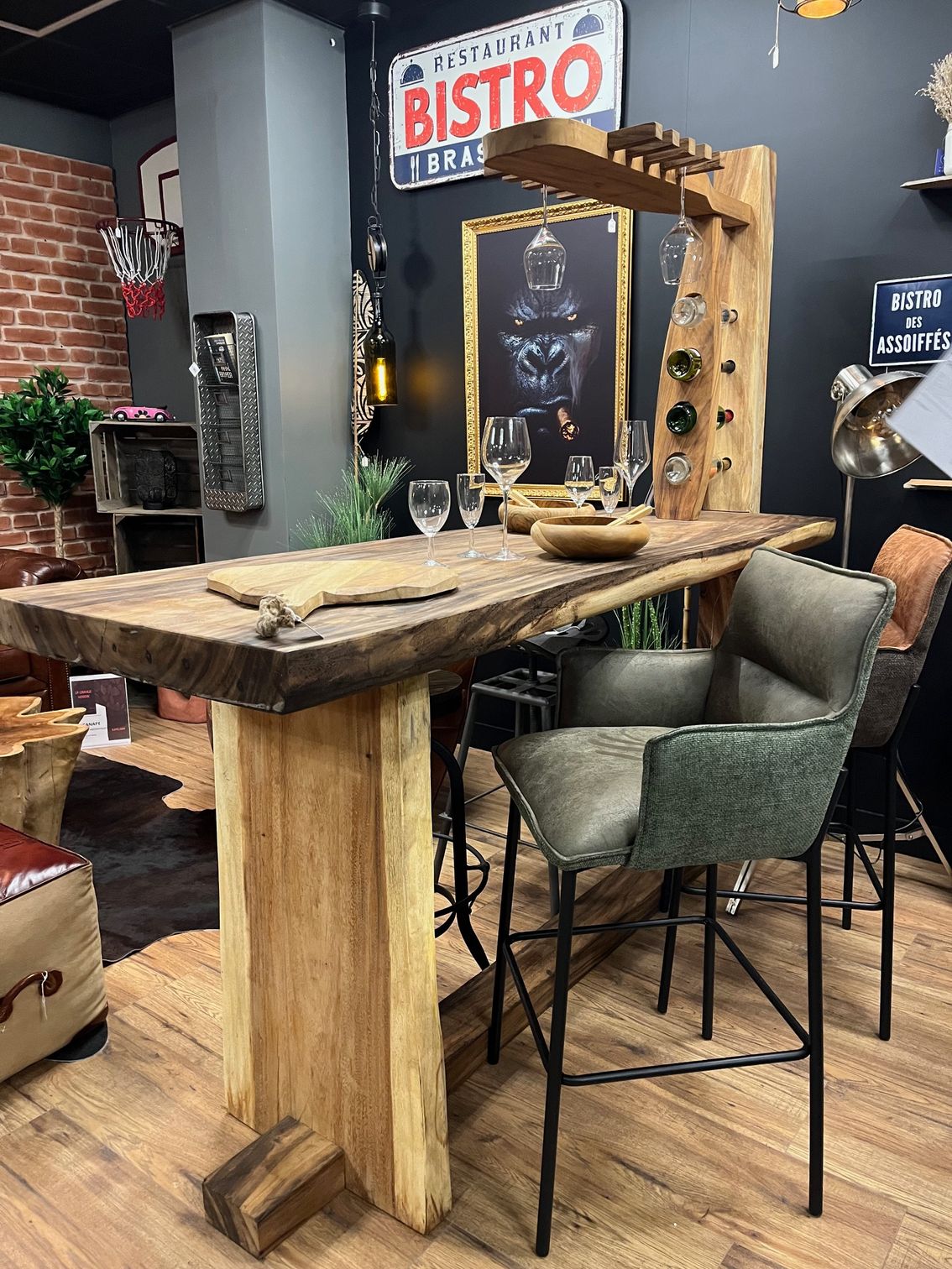 Bar rustique en bois avec tabourets, dans un intérieur élégant. Comprend un casier à vin et une enseigne de bistro.