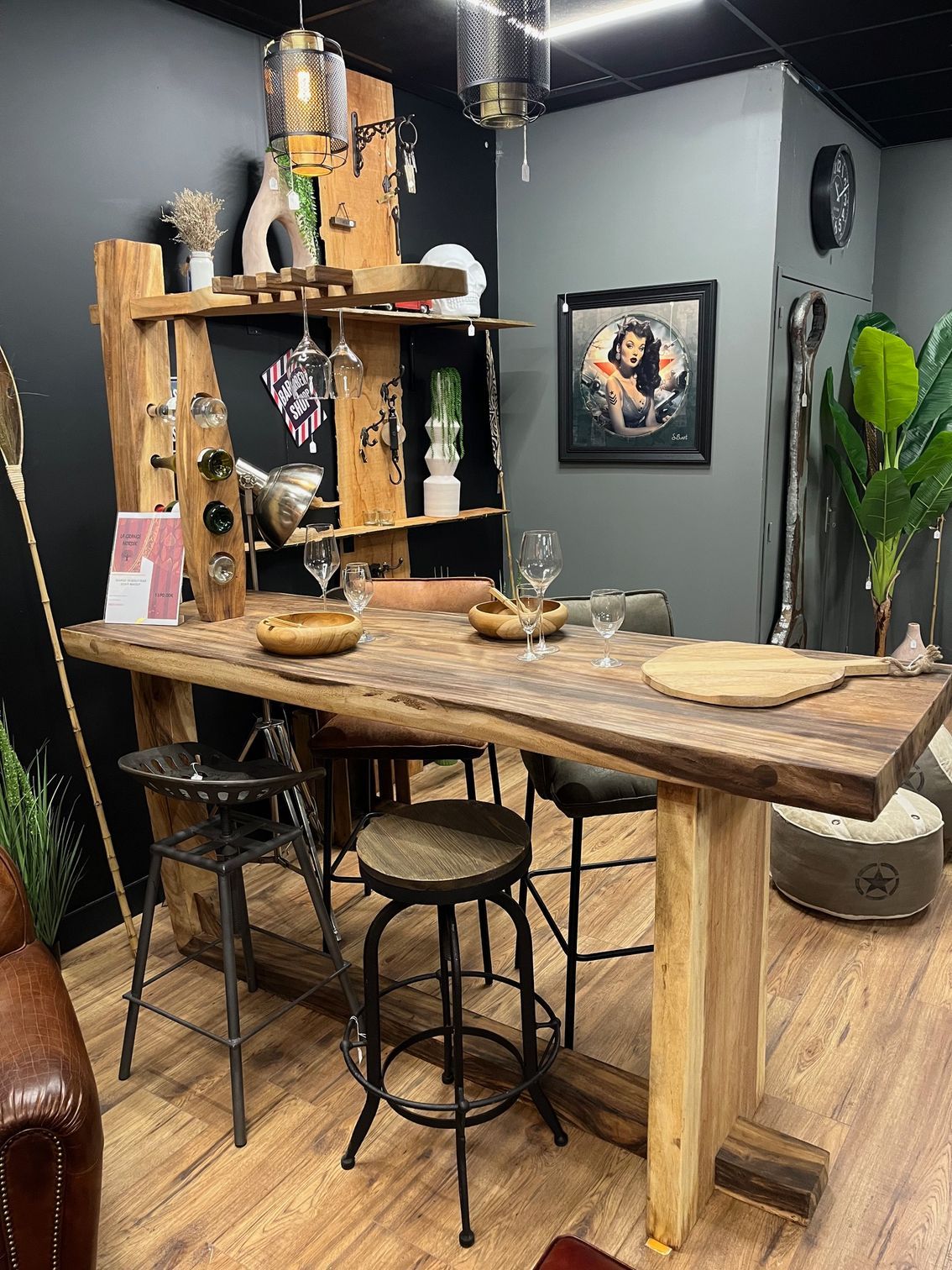 Bar en bois avec casier à vin, verrerie et objets décoratifs.