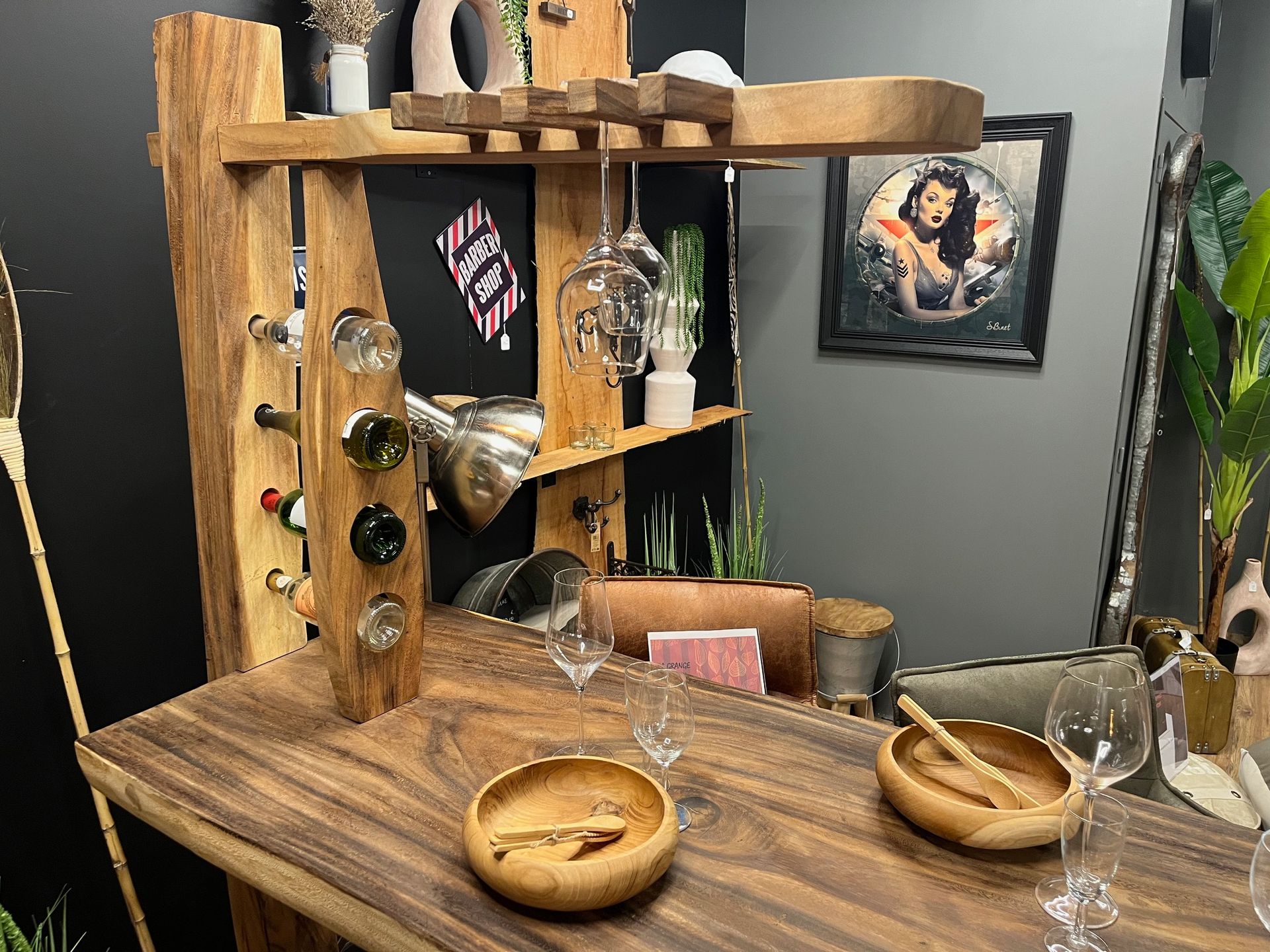 Bar en bois avec casier à vin, verrerie et objets décoratifs.