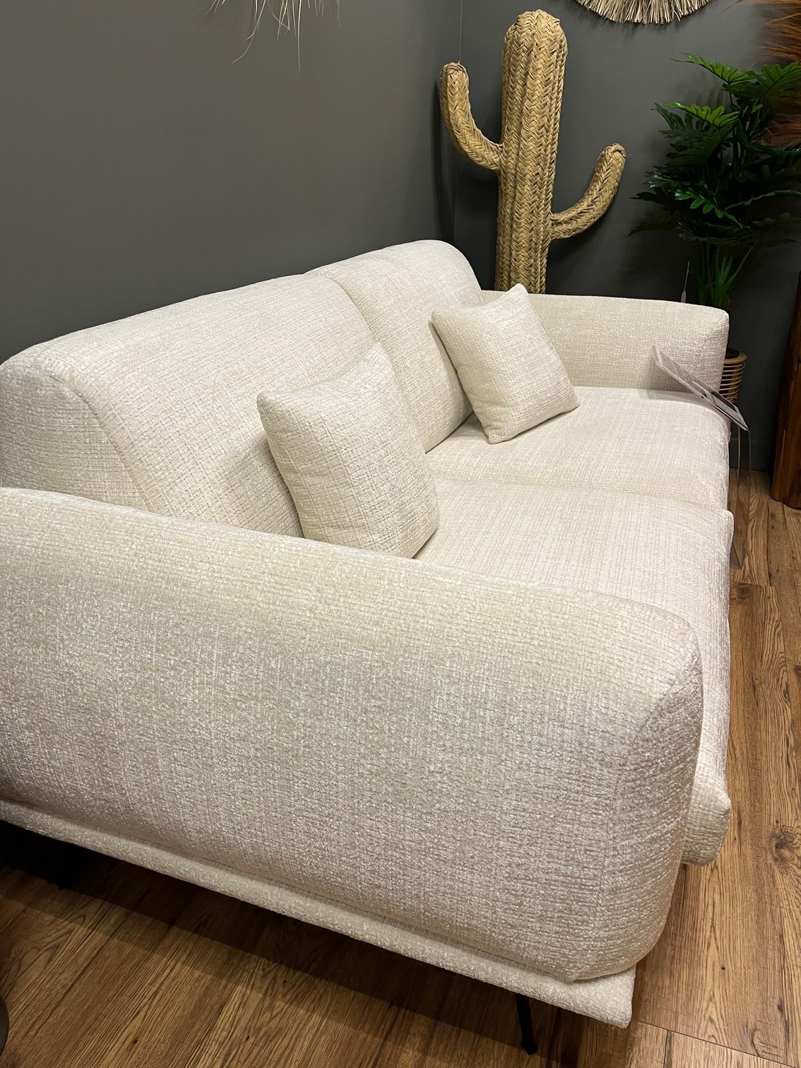 Canapé bleu avec coussin assorti dans un salon, près d'un tapis et d'une table d'appoint.