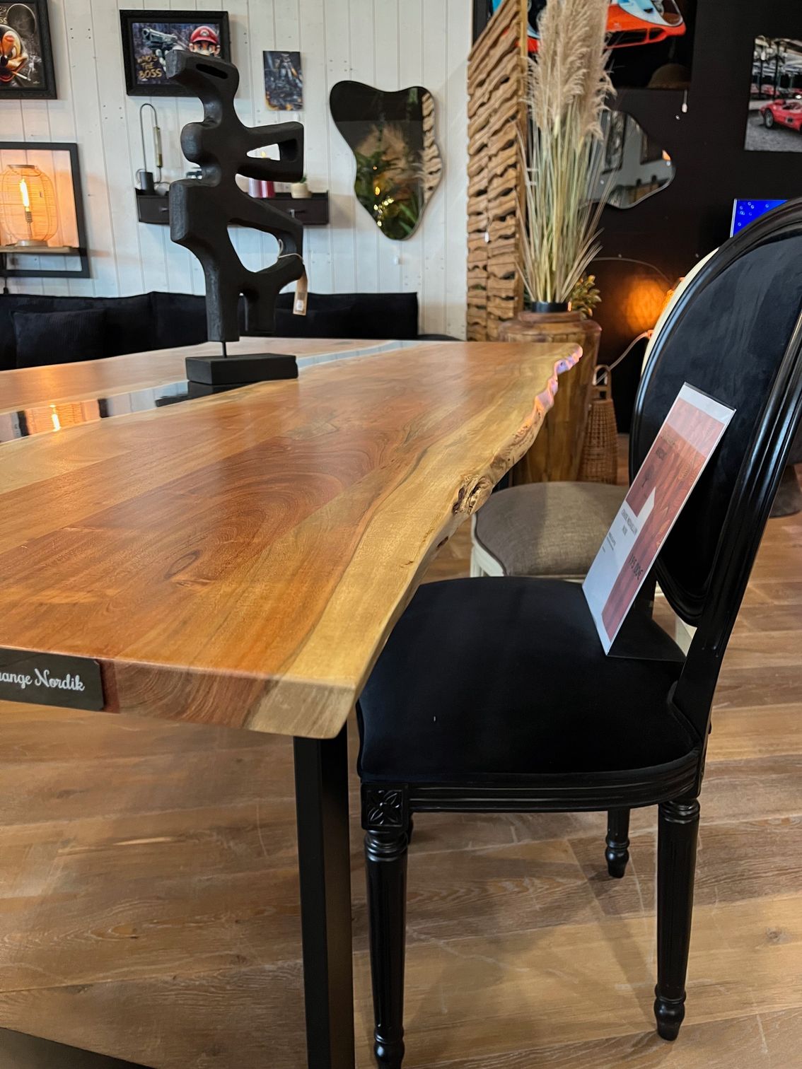 Table en bois avec rivière en époxy foncé et piètement en métal noir. Lampe et sculpture sur le dessus.