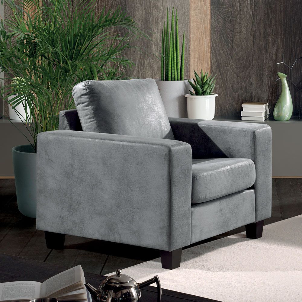 Fauteuil gris dans un salon moderne avec des plantes et un mur lambrissé