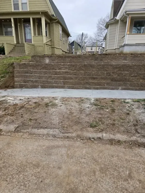 A brick wall is being built in front of a house.