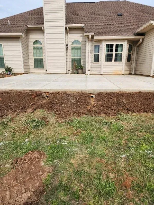 A large house with a concrete patio in front of it.