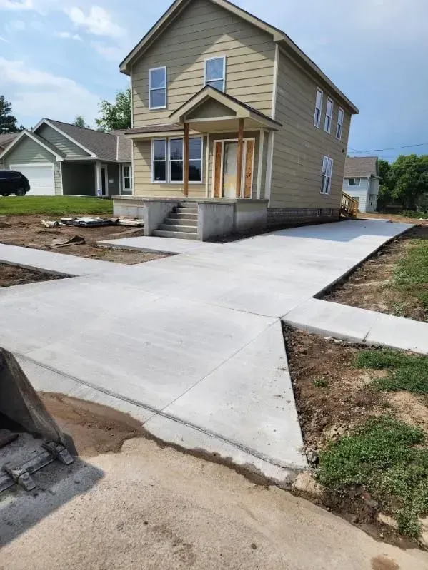 A house with a concrete driveway in front of it