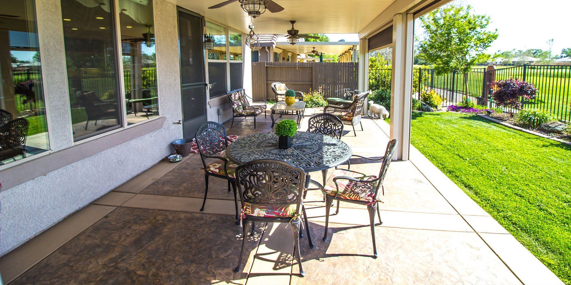 A patio with a table and chairs and a ceiling fan