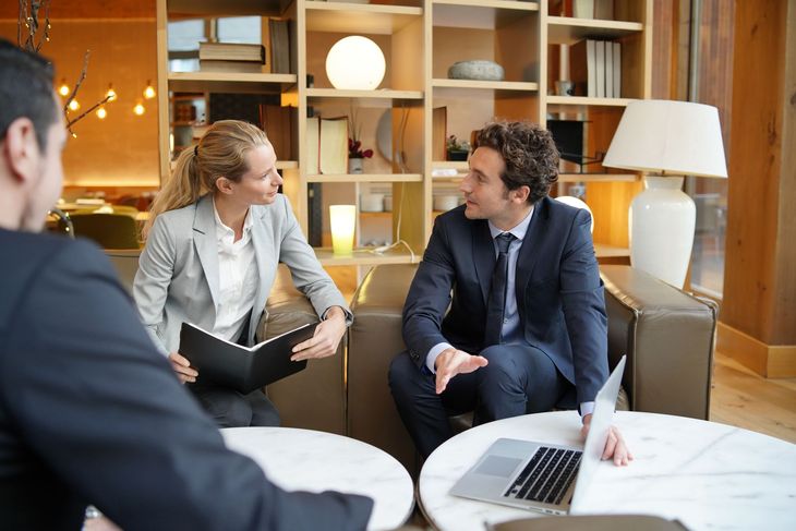 A man and a woman are sitting at a table with a laptop