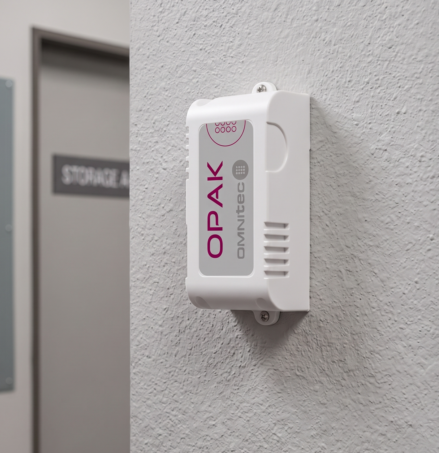 White wall-mounted OPAK device with vents and logo beside a doorway