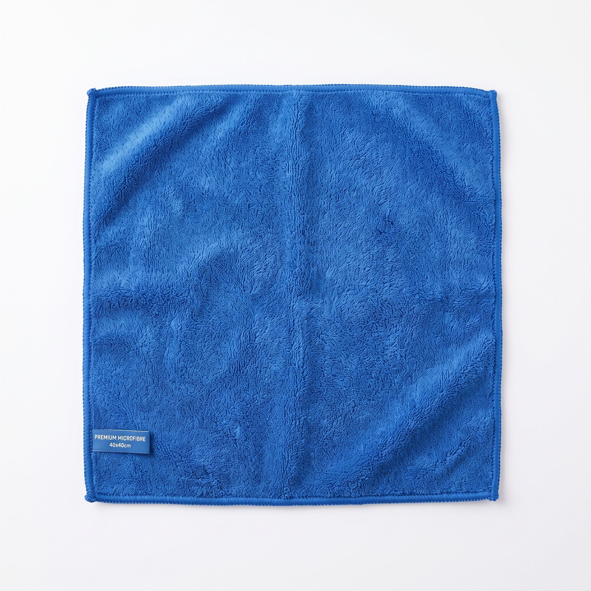 Blue textured square cloth or towel with a small label in the lower left corner