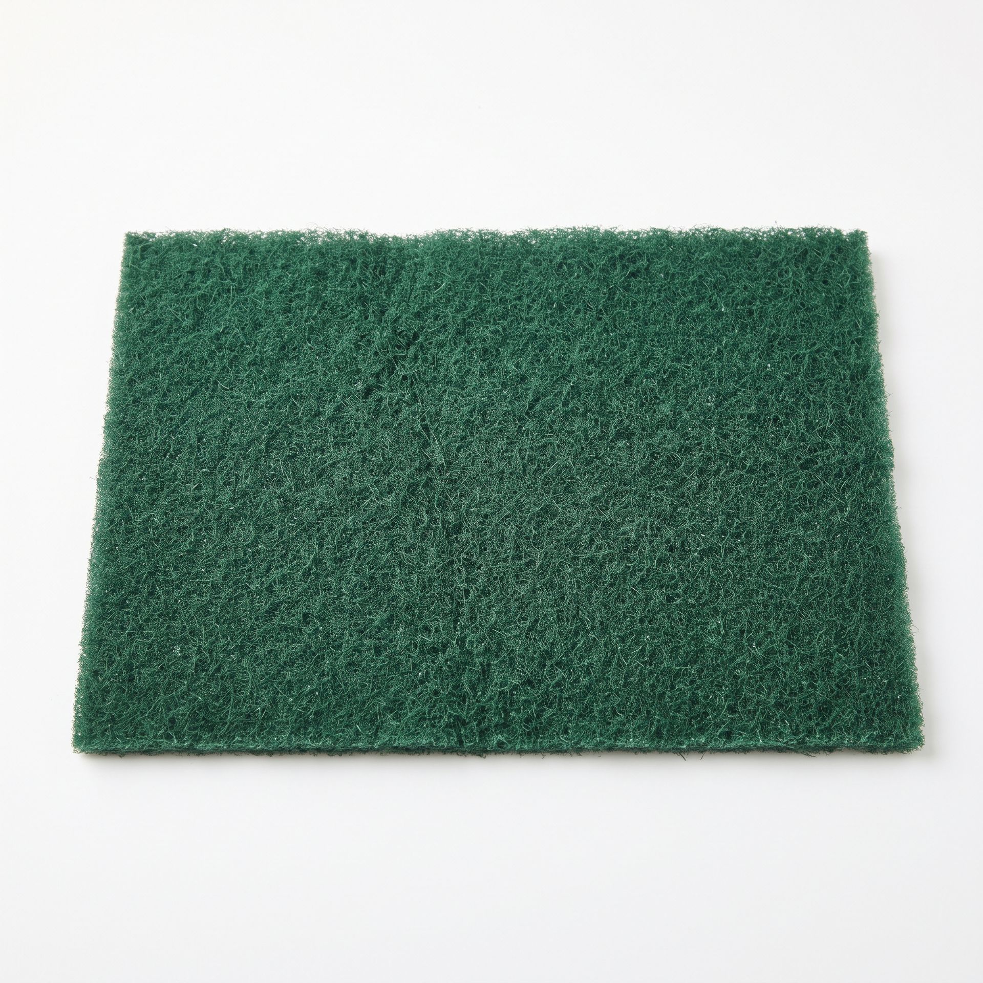 Green rectangular abrasive scouring pad on a white background