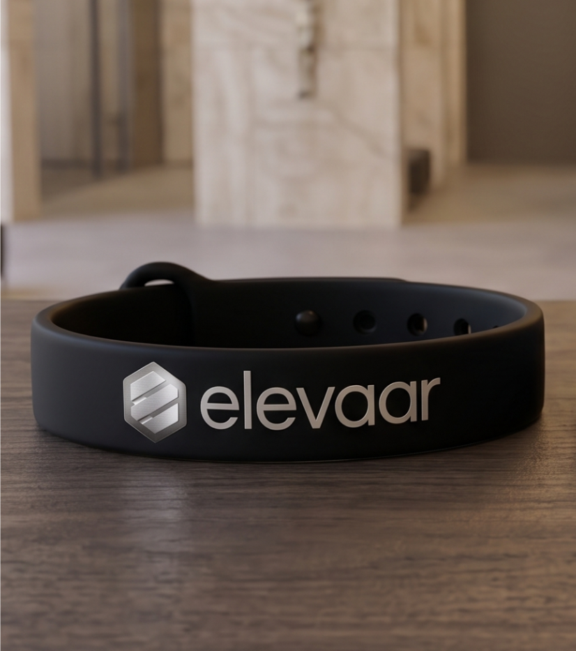 Elevaar wristband on a wooden table, one black and one dark gray.