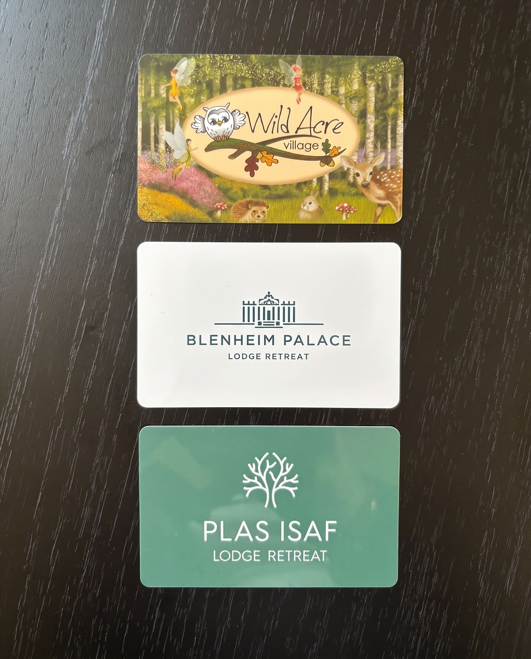 Three stacked hotel key cards on a dark textured surface.