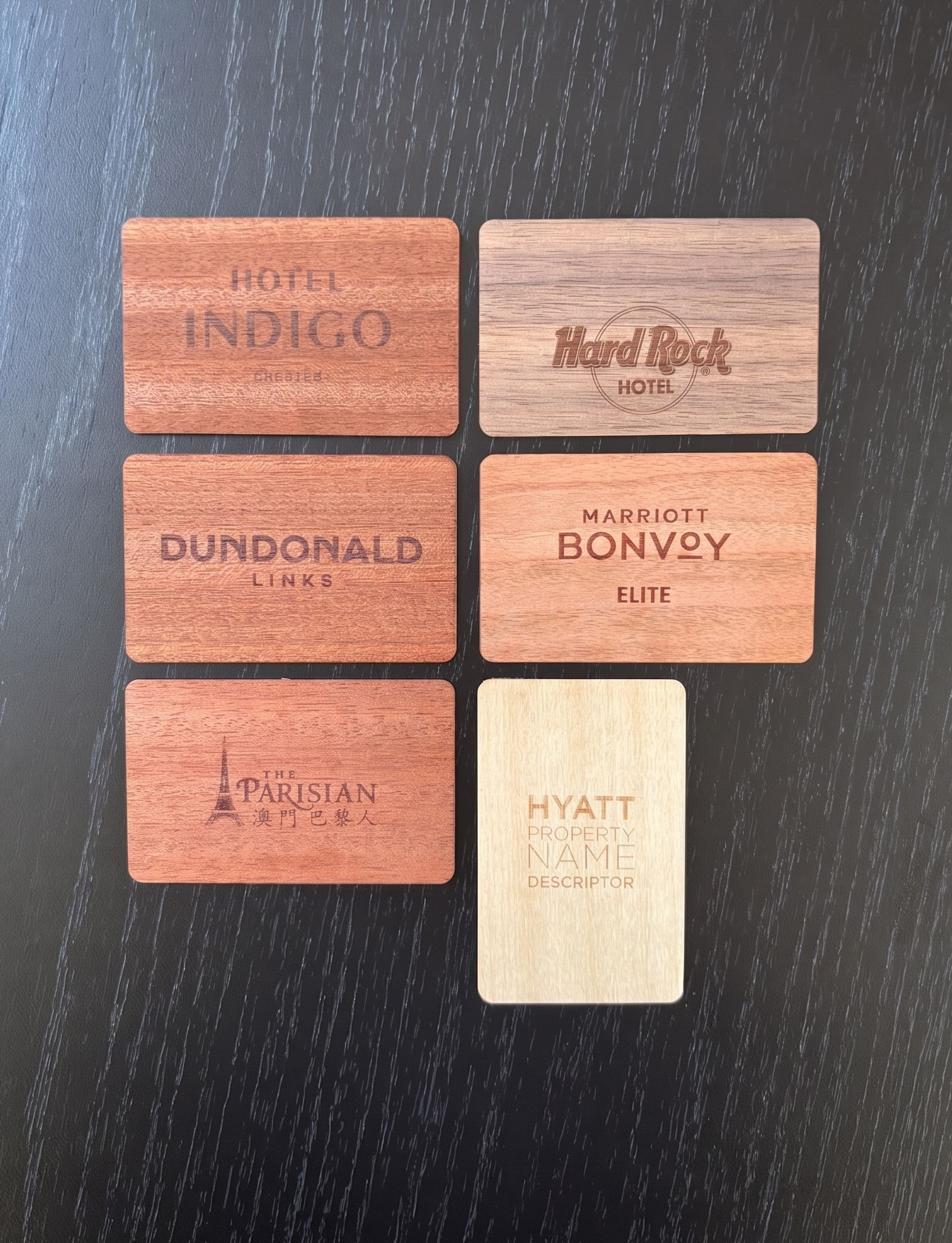 Six small wooden RFID cards with printed drink names arranged on a dark table