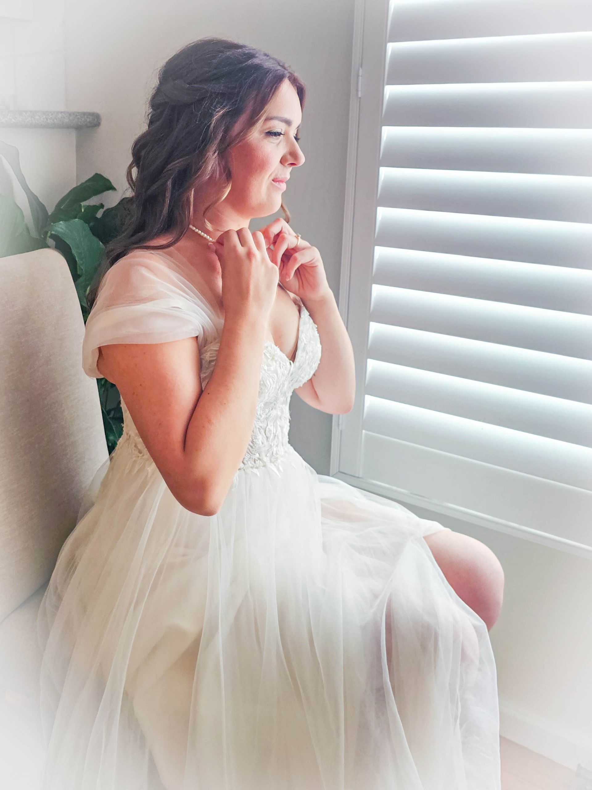 Woman In A White Dress Sitting By A Window Looking Out In Soft Light — Craig Stevens Photography in Pearl Beach, NSW