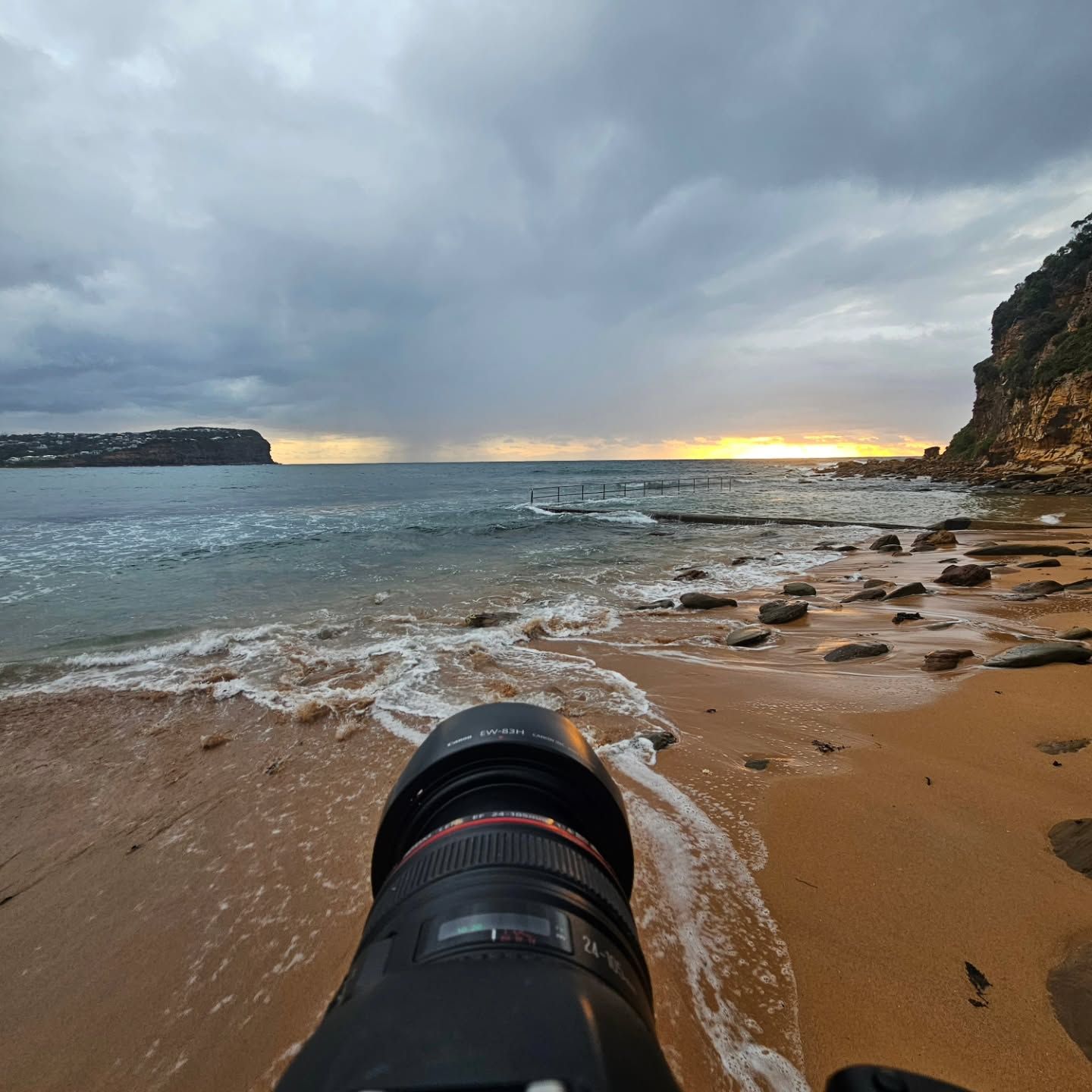 Camera Lens Pointing at A Rocky Beach and Choppy Sea Under a Cloudy Sunset Sky — Craig Stevens Photography in Pearl Beach, NSW