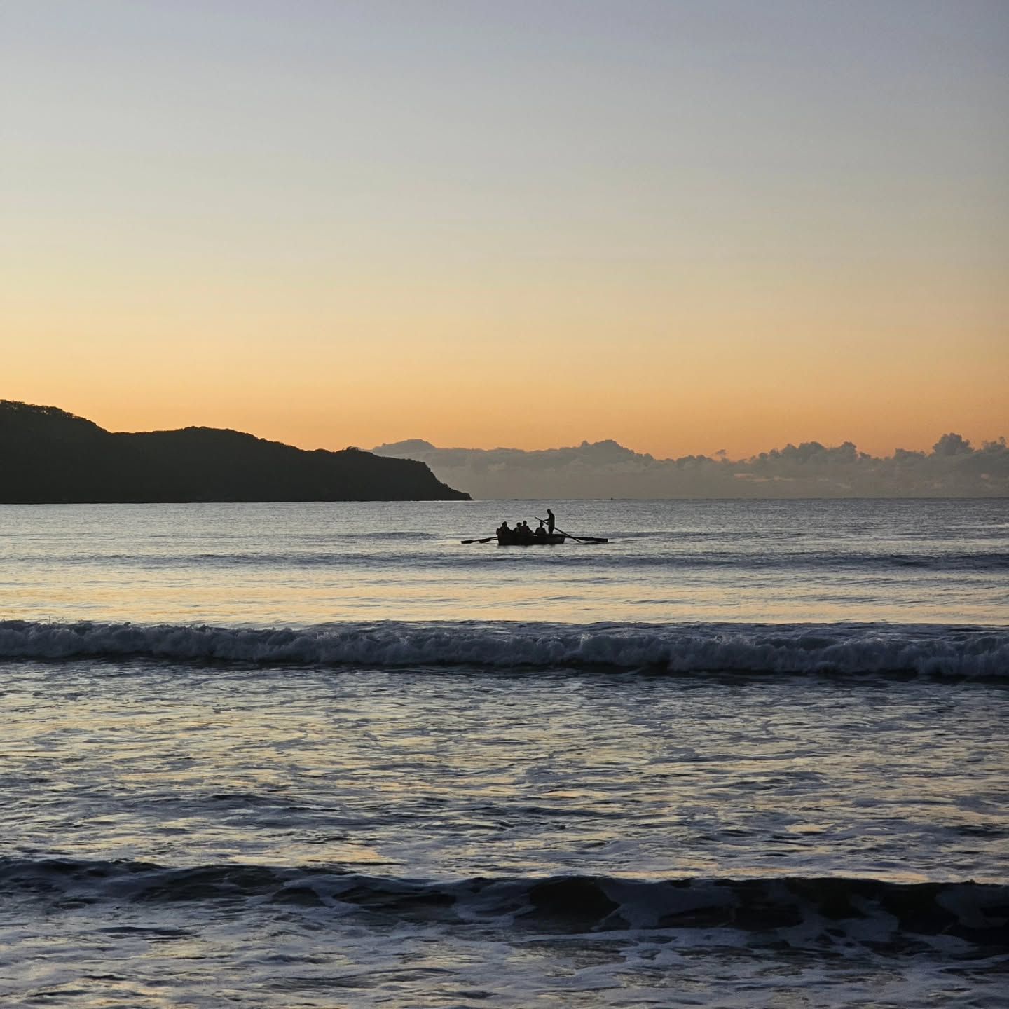 Small Boat on Calm Ocean at Sunset, with Dark Shoreline and Distant Islands Silhouetted on The Horizon — Craig Stevens Photography in Pearl Beach, NSW