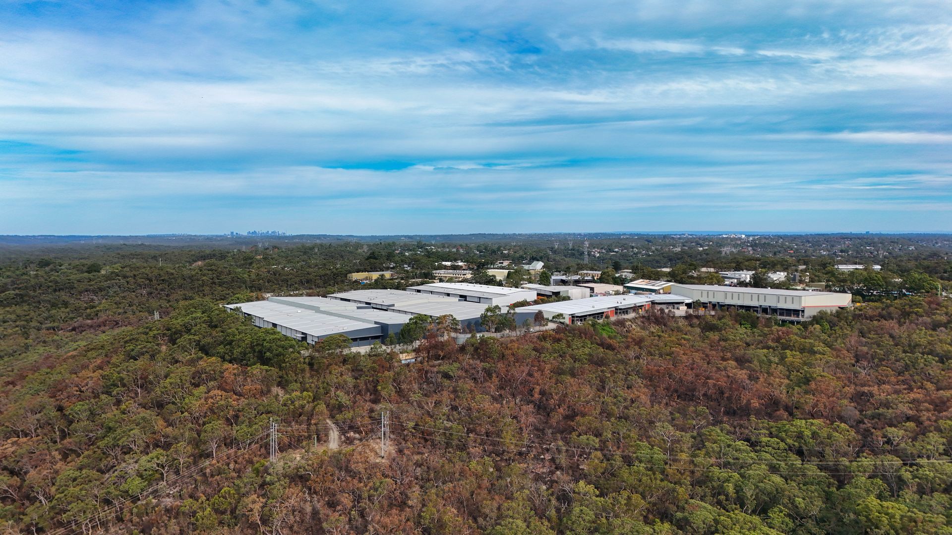 Aerial View Of A Large White-roofed Facility Surrounded By Dense Forest — Craig Stevens Photography in Pearl Beach, NSW