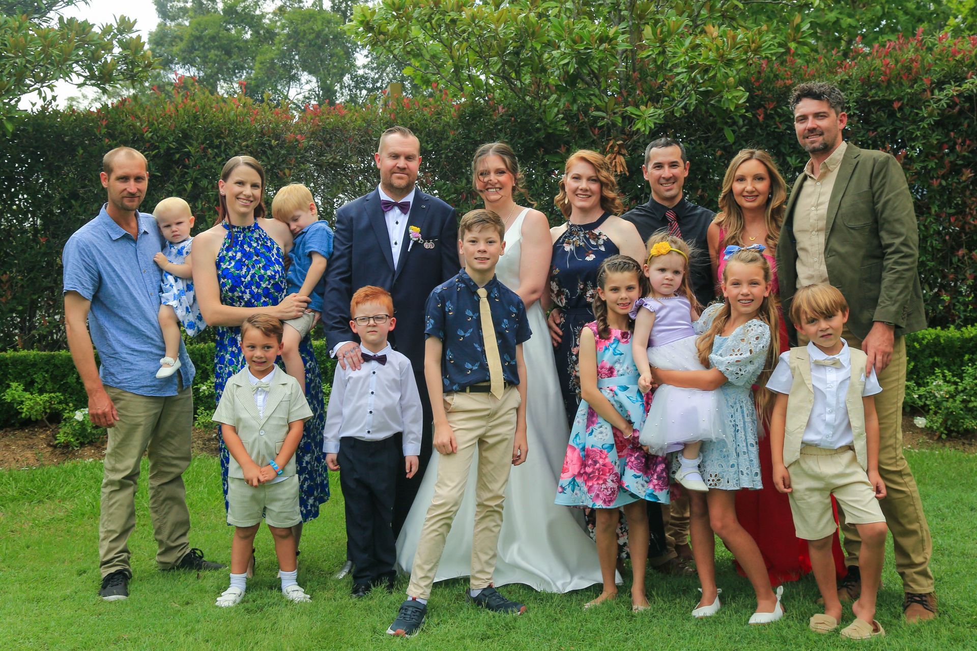 Large Family Group Posing Outdoors in A Garden, Wearing Formal and Colorful Clothes — Craig Stevens Photography in Pearl Beach, NSW