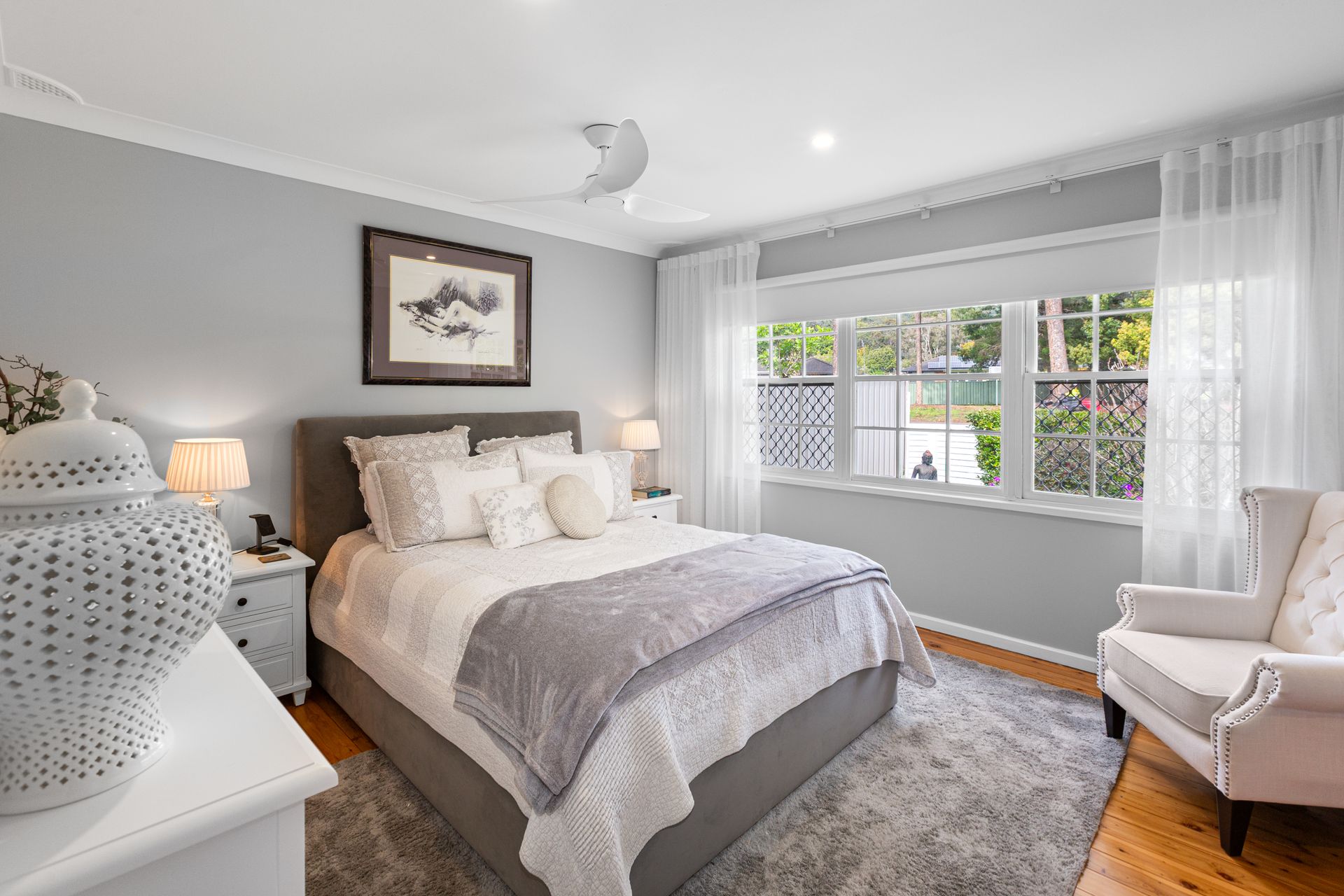 Bright Gray Bedroom With A Bed, Armchair, Lamp, And Large Window — Craig Stevens Photography in Sydney, NSW