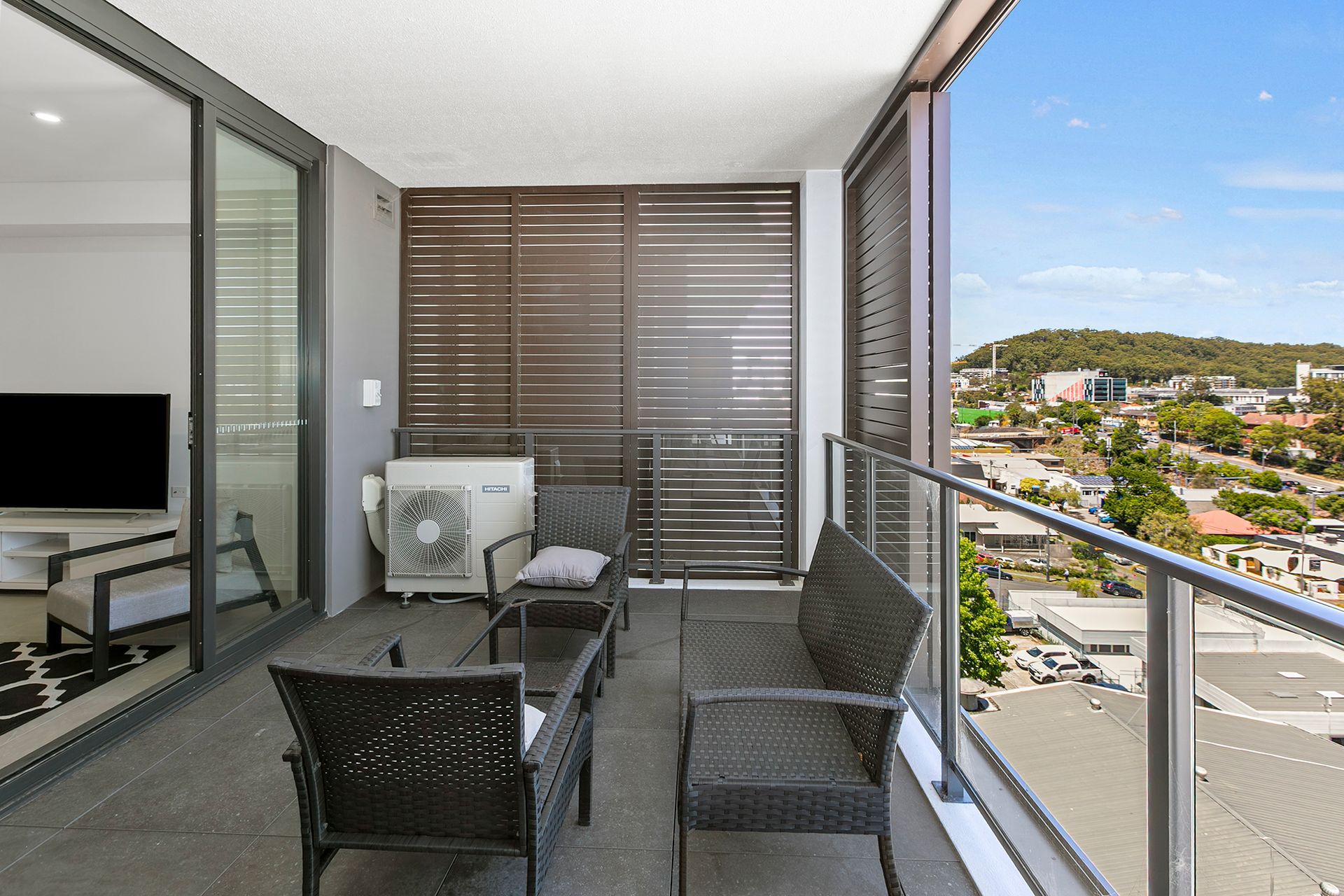 Balcony With Dark Patio Chairs, Table, And City View — Craig Stevens Photography in Pearl Beach, NSW