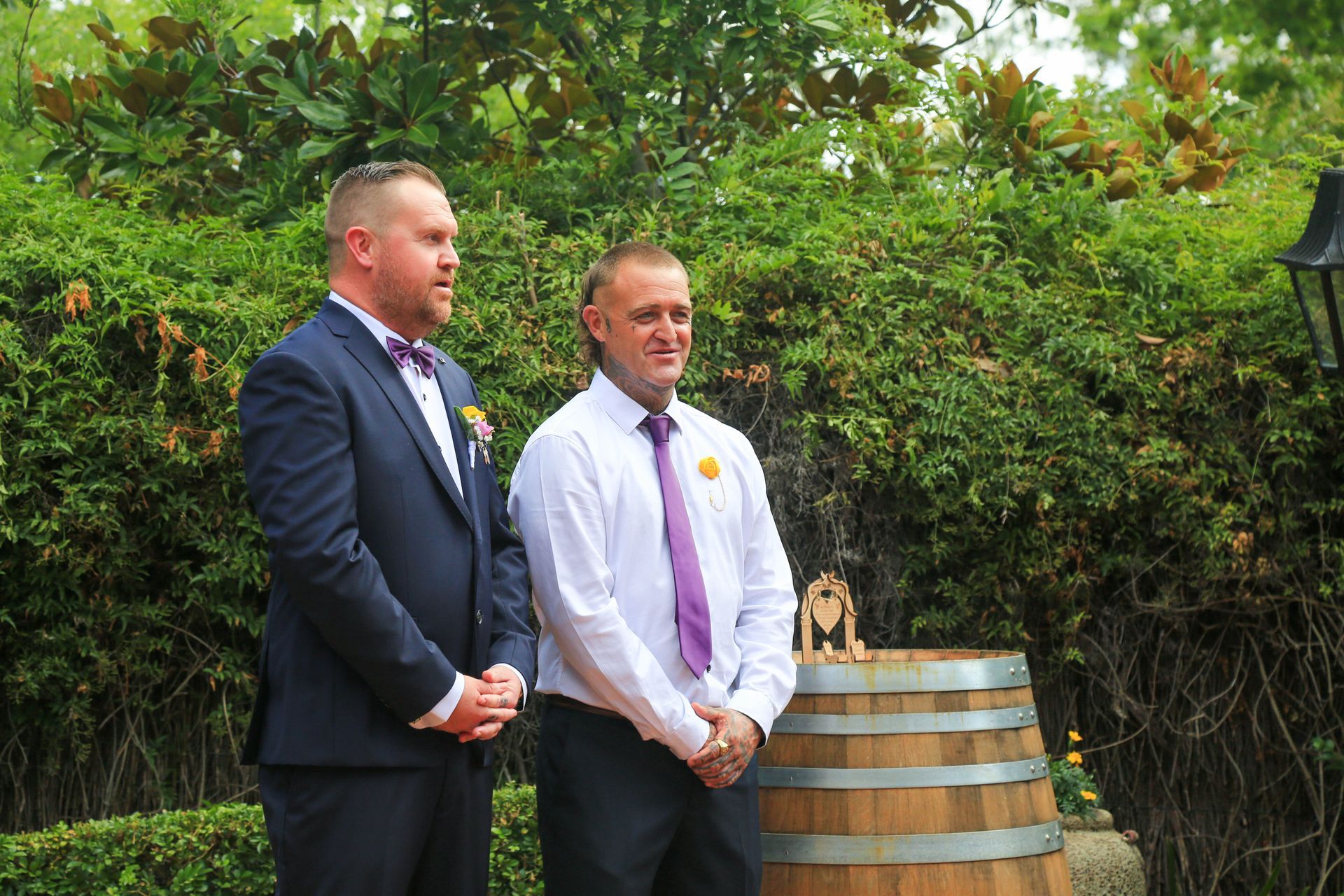 Two People in Formal Attire Stand Beside a Wooden Barrel Outdoors in A Garden — Craig Stevens Photography in Pearl Beach, NSW