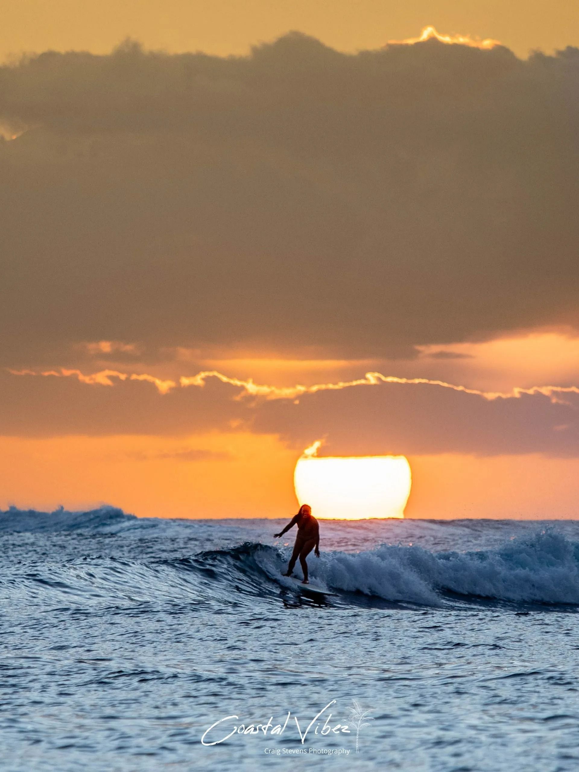 Surfer Riding A Wave At Sunset With A Glowing Orange Horizon — Craig Stevens Photography in Pearl Be
