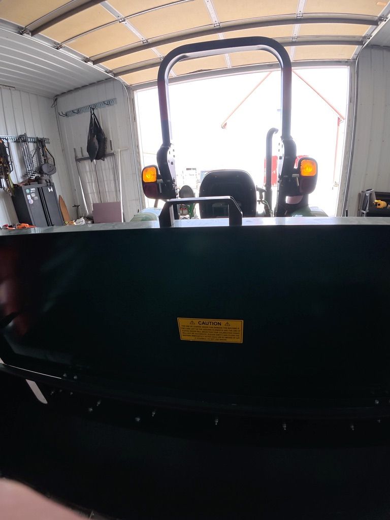 Inside a van or trailer, looking toward the open rear with tools and a black seat in the foreground.