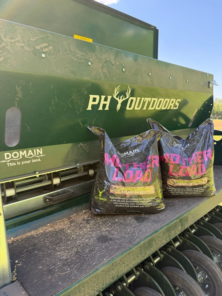 PH Outdoors ammo boxes and two purple-and-black bags on a textured gun case table