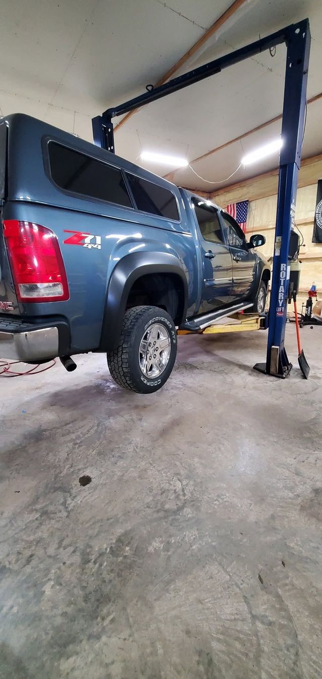 Blue SUV lifted on a garage car hoist inside an auto repair shop | Stone Lake Auto
